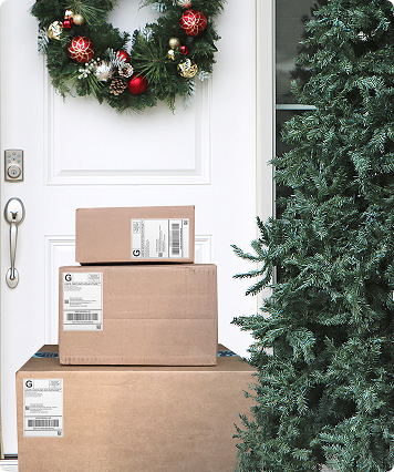 A door with a wreathe on in and packages stacked in front of it.